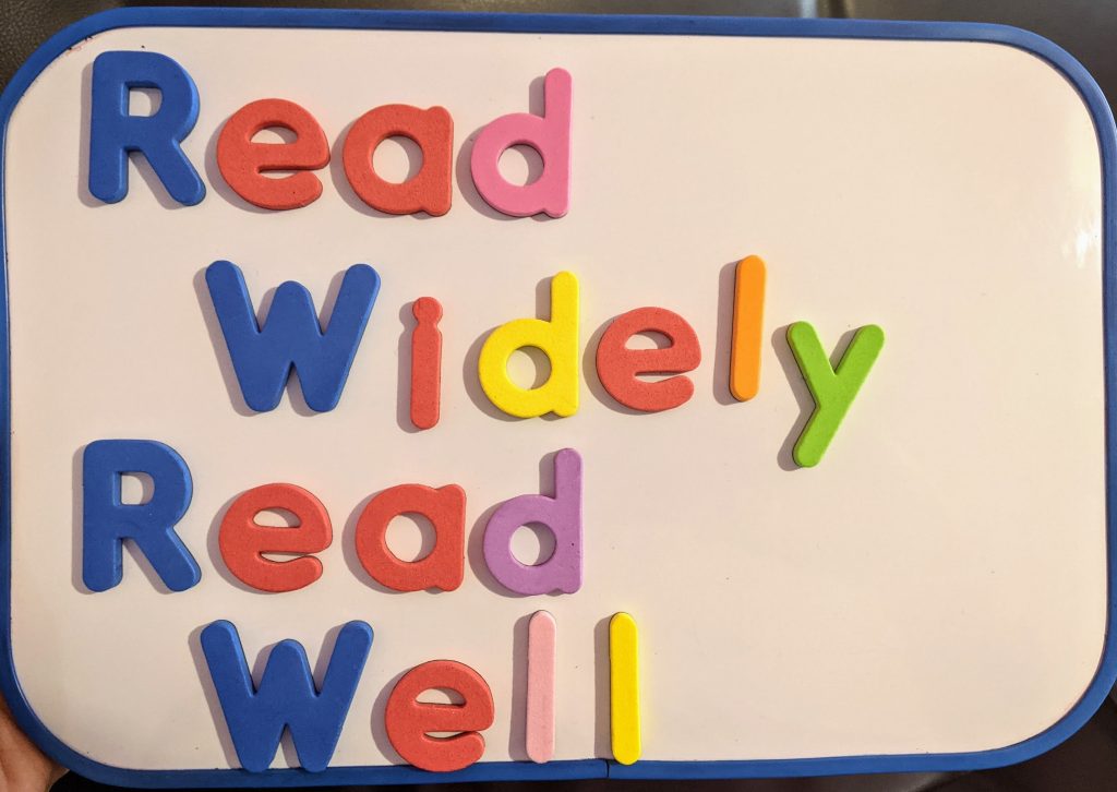 'Read Widely Read Well' spelt out in foam letters on a magnetic whiteboard.